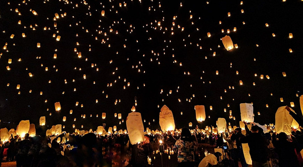 group of people throwing paper lantern on sky during night